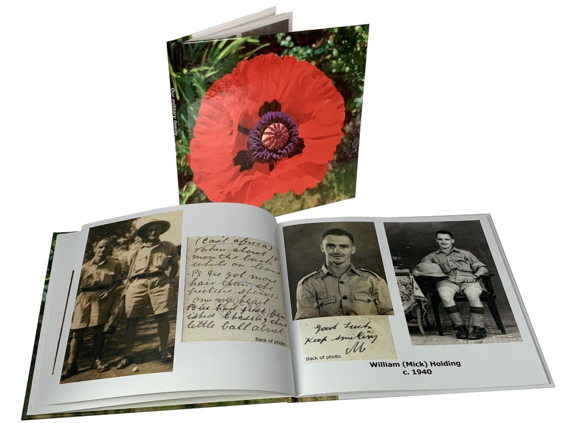 A photo book containing military photos with a poppy on the cover